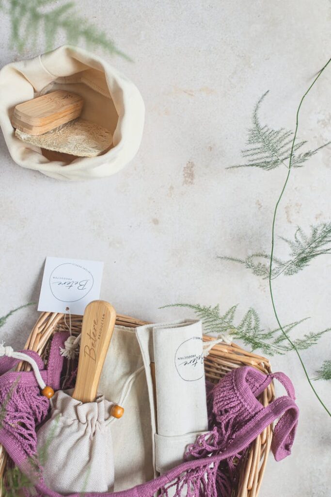 Sustainable zero waste products in a basket with greenery on a white background.
